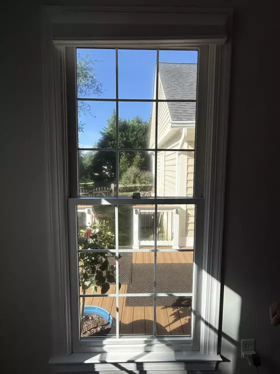 Interior view of a window with trim looking out to a deck