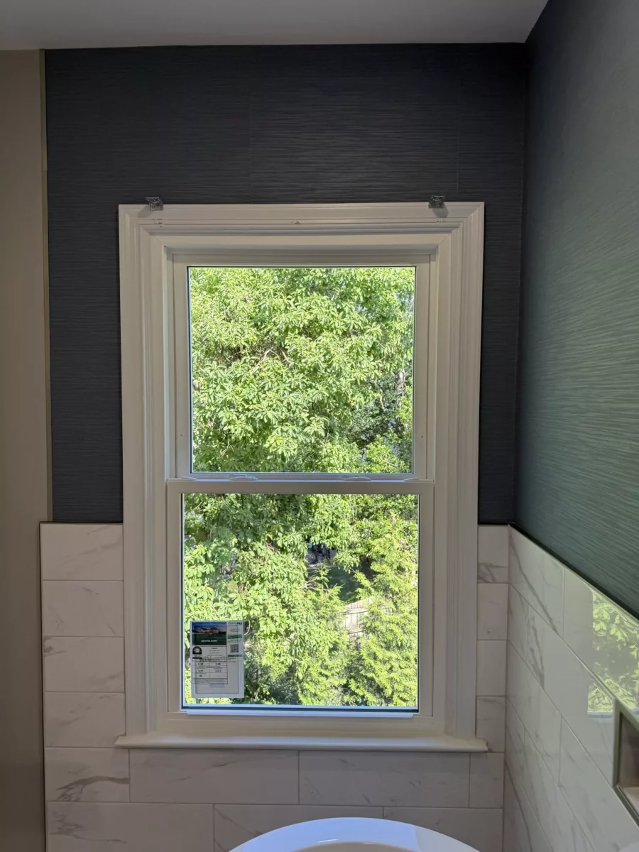 Newly installed window with white frame and tile wall in bathroom