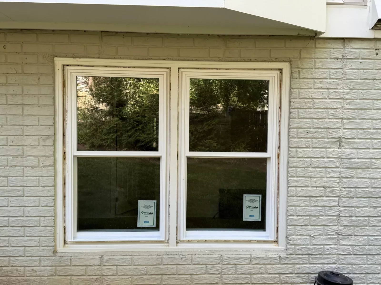 Completed exterior window replacement in Rockville, MD, featuring two energy-efficient double-hung windows in a brick wall.