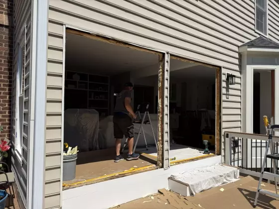 Full-frame patio door replacement in progress, with old units removed and openings prepared for new energy-efficient doors in Rockville, MD.