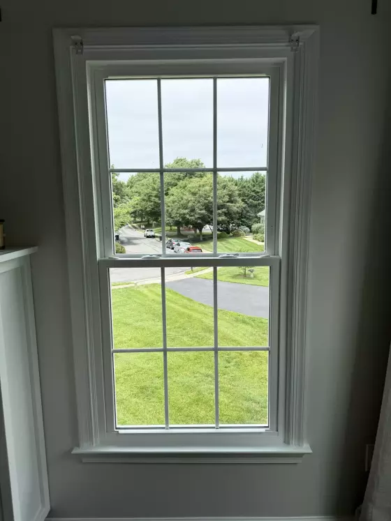 Energy-efficient double-hung window replacement in Rockville, MD, with grids and professionally finished interior trim.