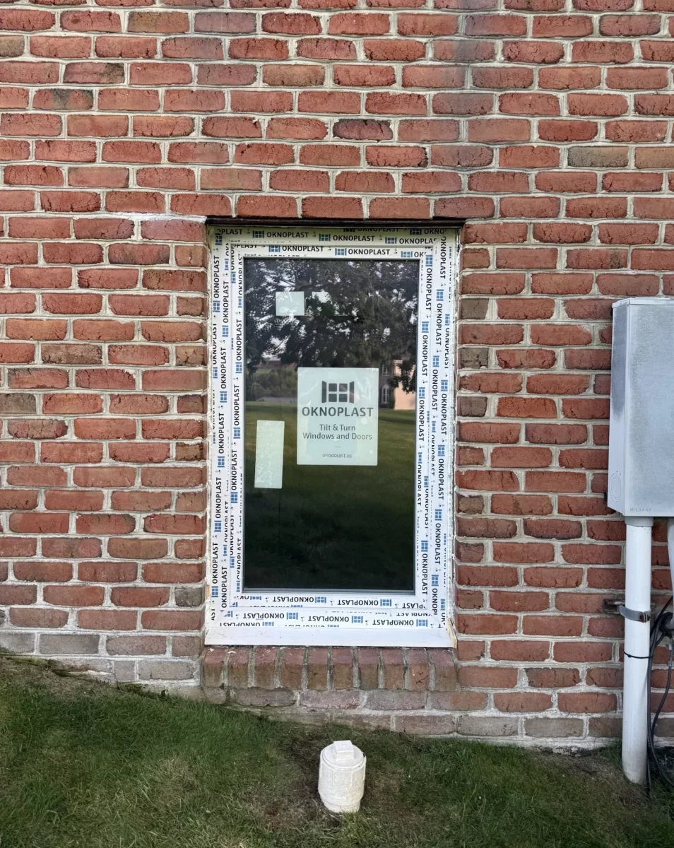 New window with protective film installed in brick exterior wall