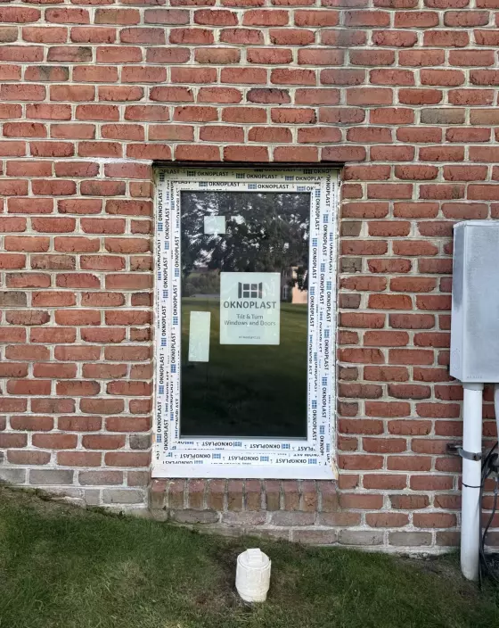 New window with protective film installed in brick exterior wall