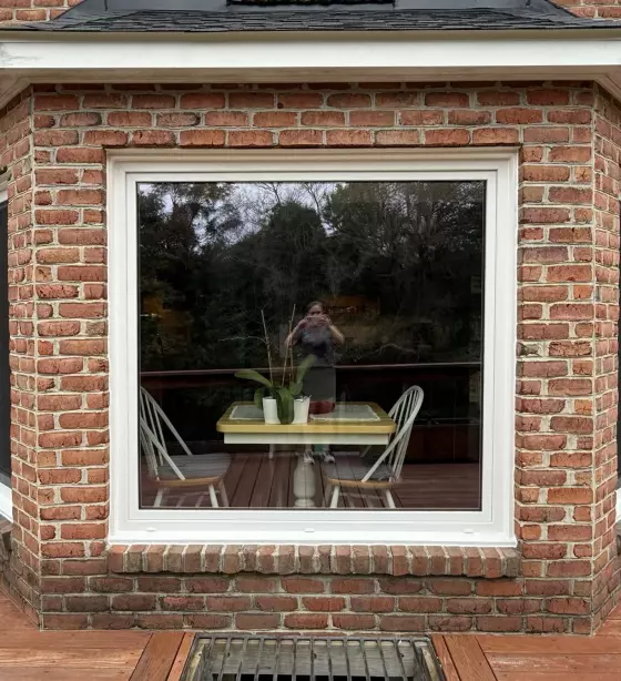 Large window with white frame on brick exterior wall
