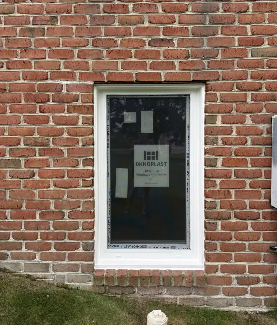 Exterior view of a new tilt and turn window installed in a brick wall