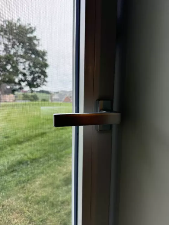 Close-up of window handle and screen from interior