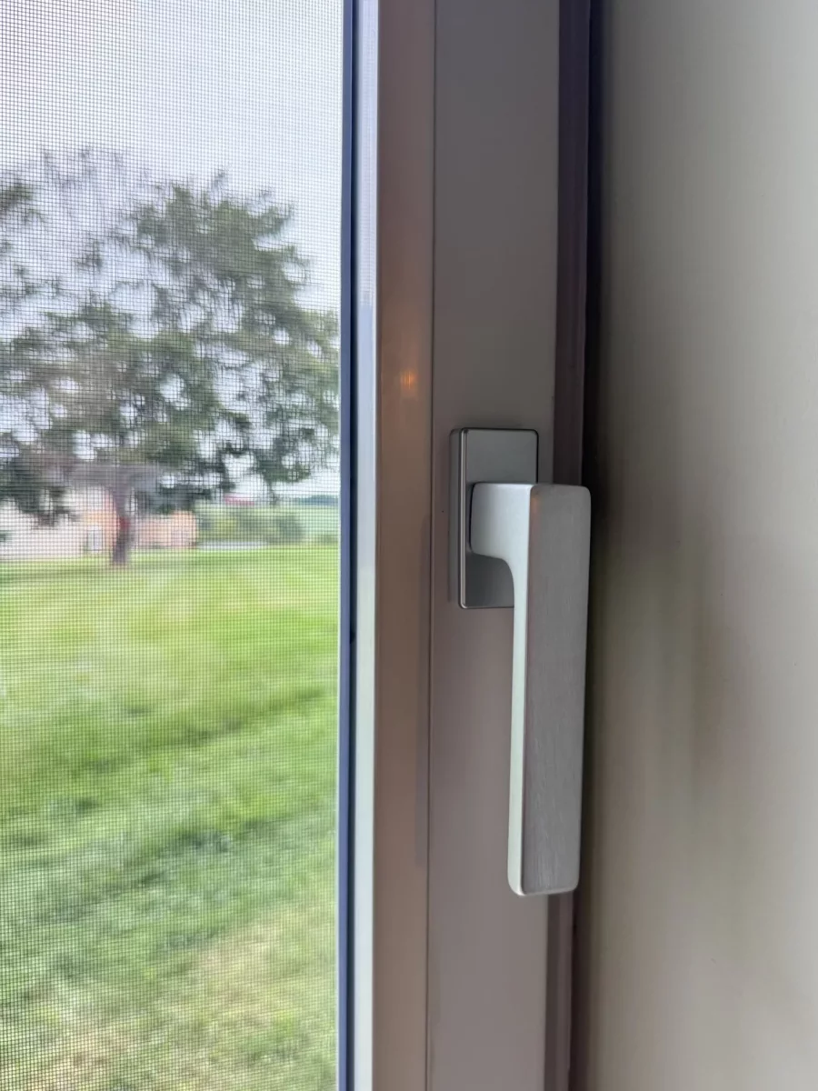 Close-up of a tilt and turn window handle and screen
