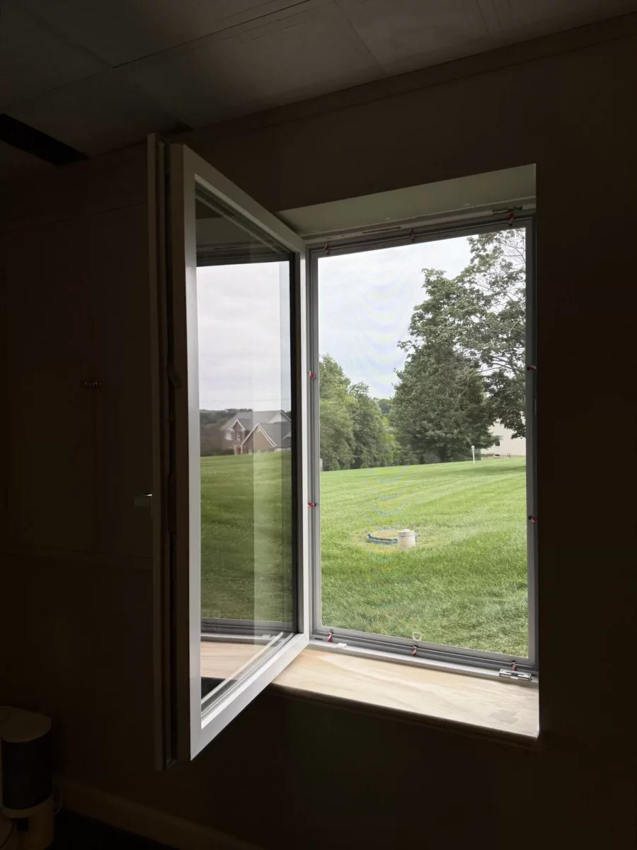 Open tilt and turn window with view of grass and trees