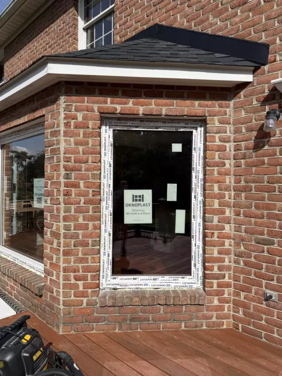 New window installation with protective film on brick exterior wall
