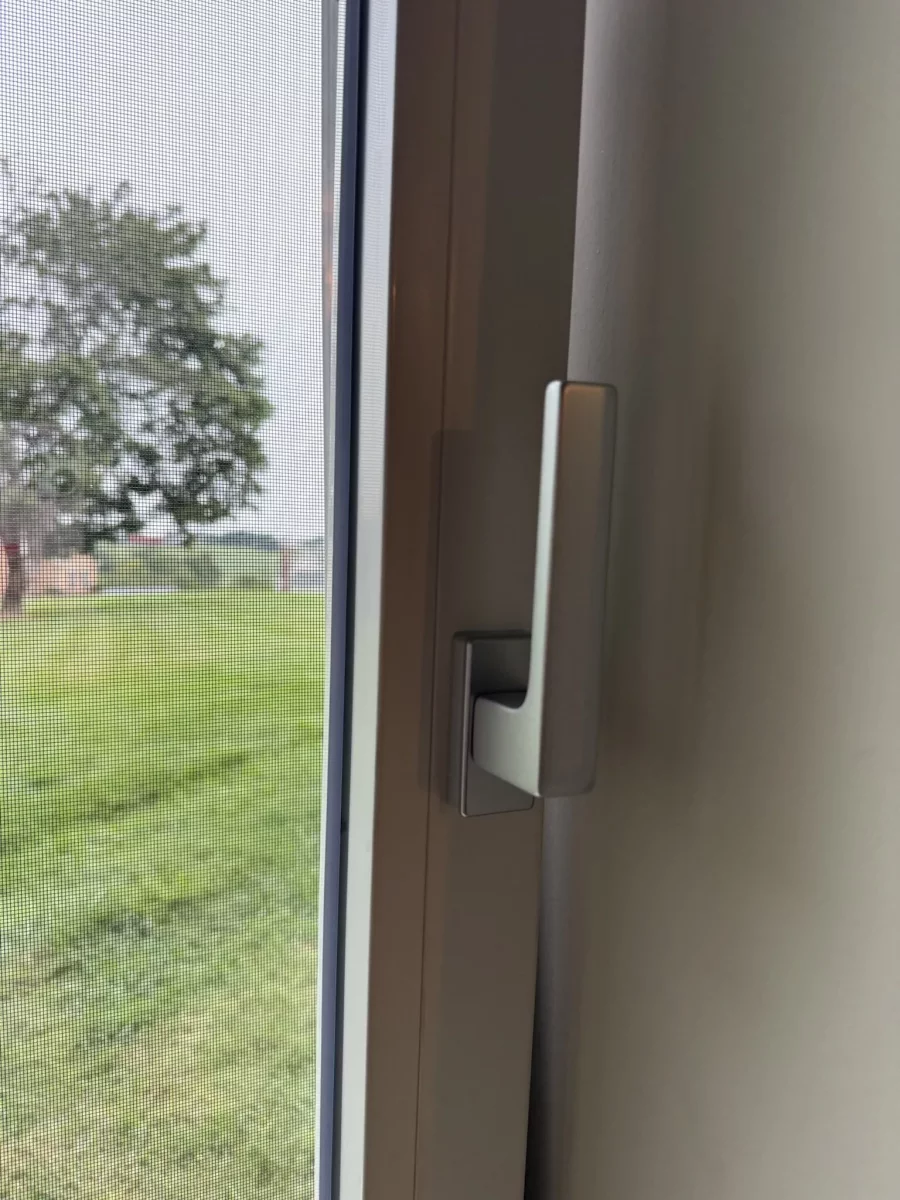 Close-up of window handle and screen from inside