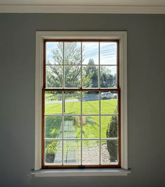 Single window with grid pattern and white trim in interior wall