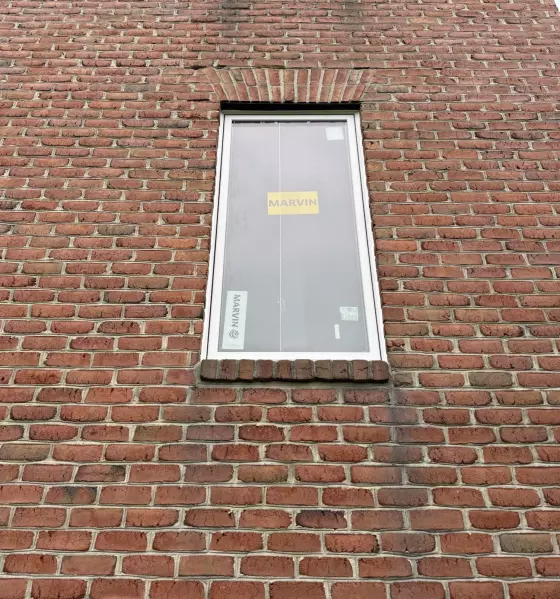 Brick exterior with new window installation in progress