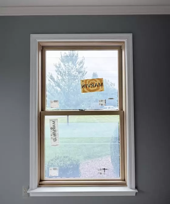 New window with protective labels installed in painted interior wall