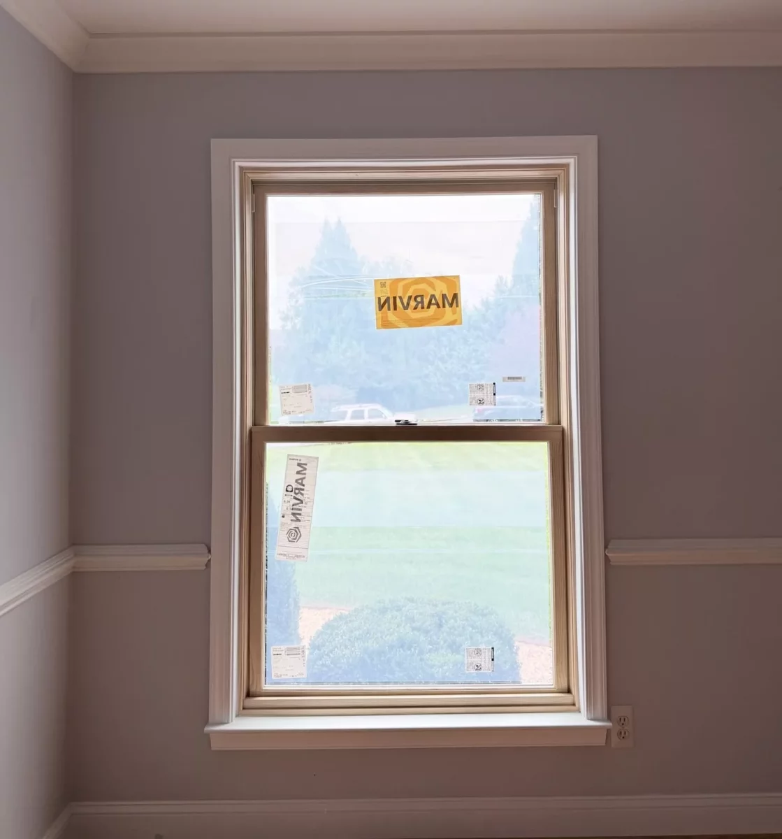 New Marvin Elevate double-hung window after full-frame replacement with natural wood interior and finished white trim.