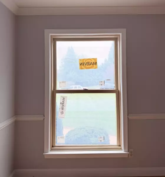 New Marvin Elevate double-hung window after full-frame replacement with natural wood interior and finished white trim.