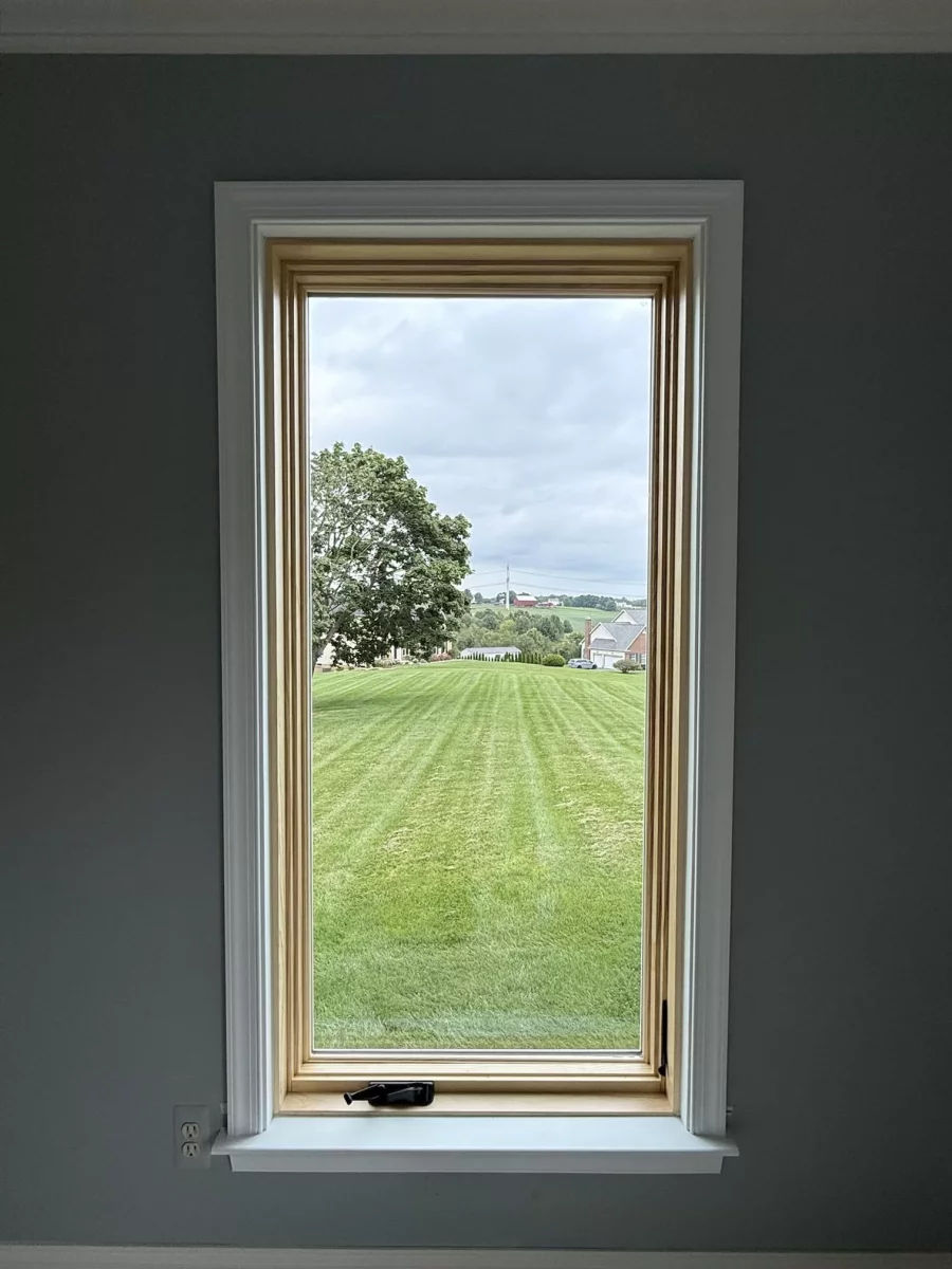 New Marvin Elevate casement window shown after full-frame replacement, with a natural-wood interior and finished white trim.
