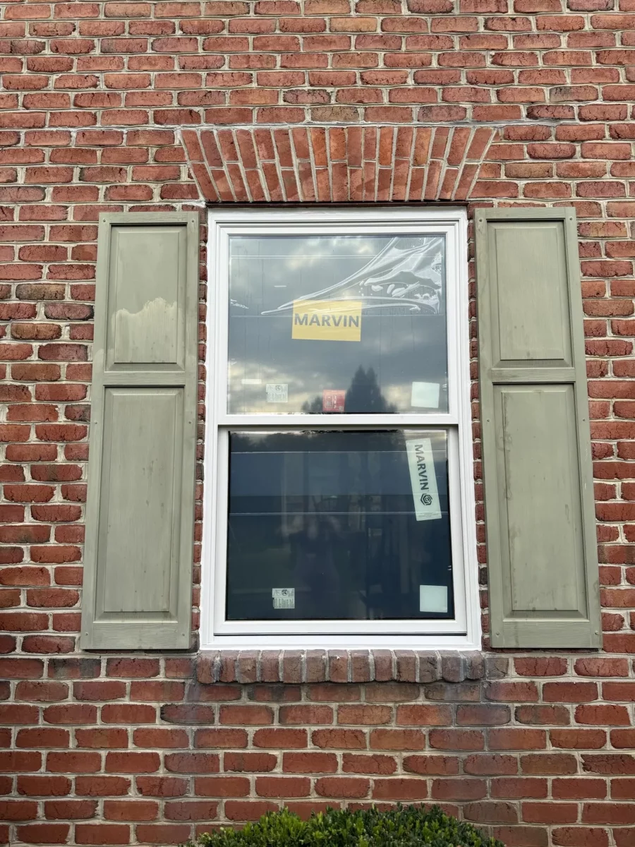 New window with protective film installed in brick exterior wall