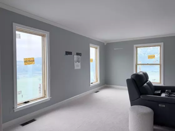 New Marvin Elevate windows after full-frame replacement with natural wood interiors and finished white trim.