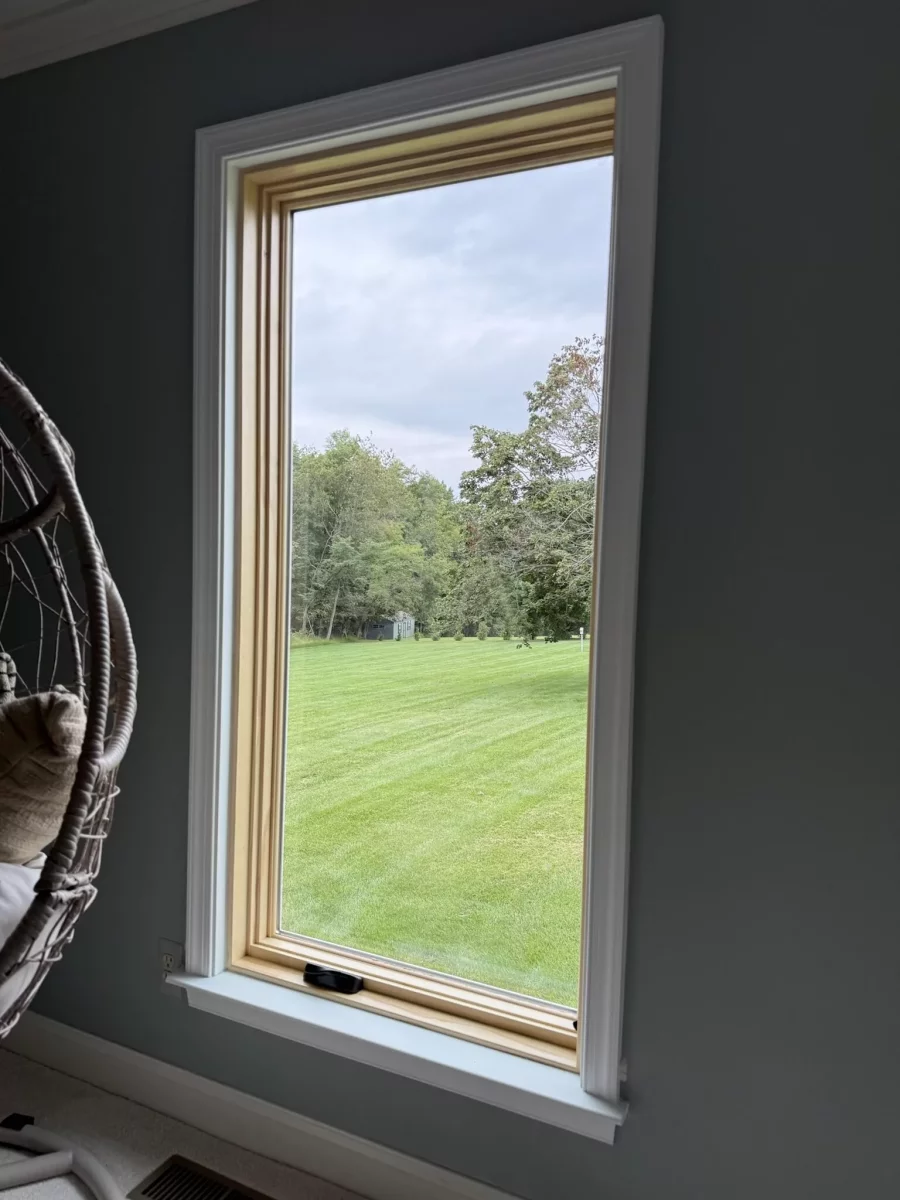 New Marvin Elevate casement window shown after full-frame replacement, with a natural-wood interior and finished white trim.