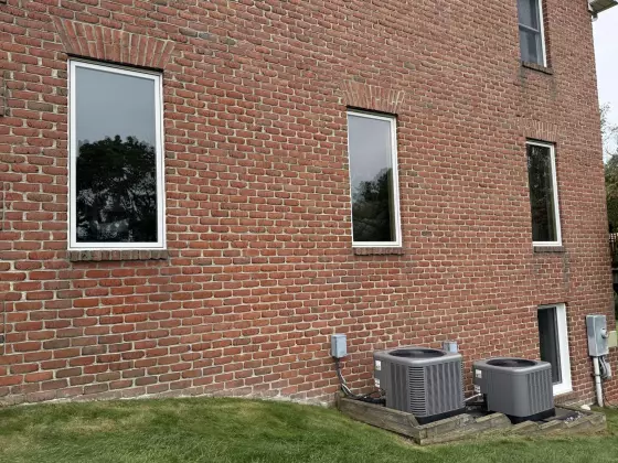 Four modern windows installed in a brick exterior wall