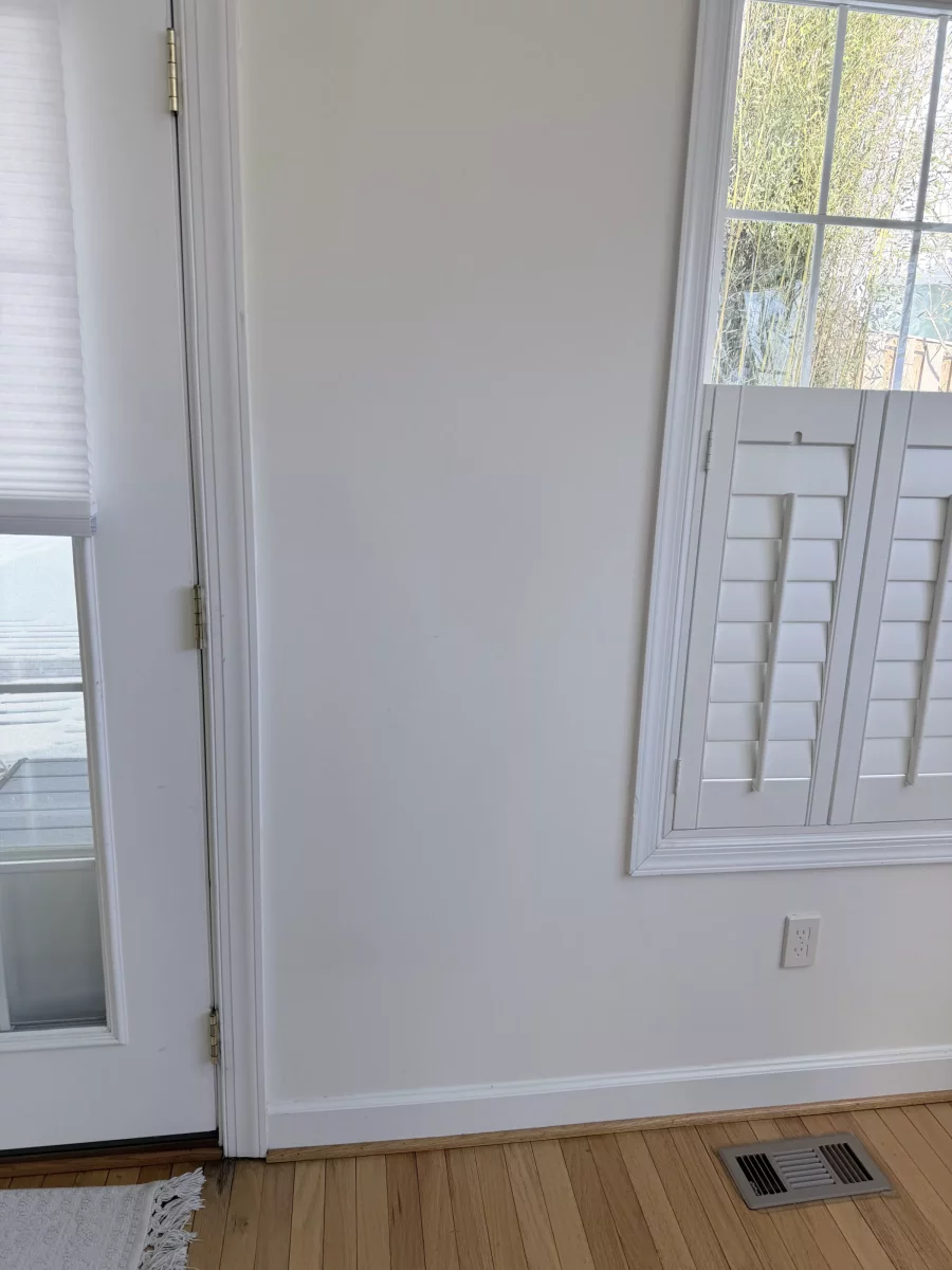 Interior view of a door and window with white trim and wood floor