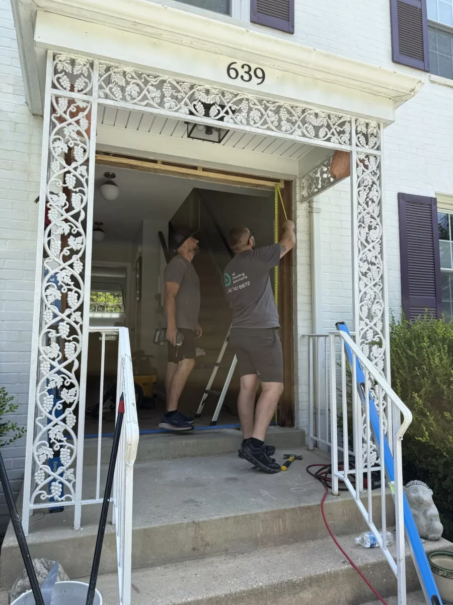 Installers measuring rough opening after full removal of old door and sidelites for new ProVia entry door in Rockville, MD