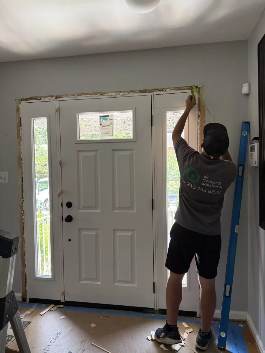 Interior view of new ProVia door with beveled glass sidelites as installer measures for trim and casing in Rockville, MD