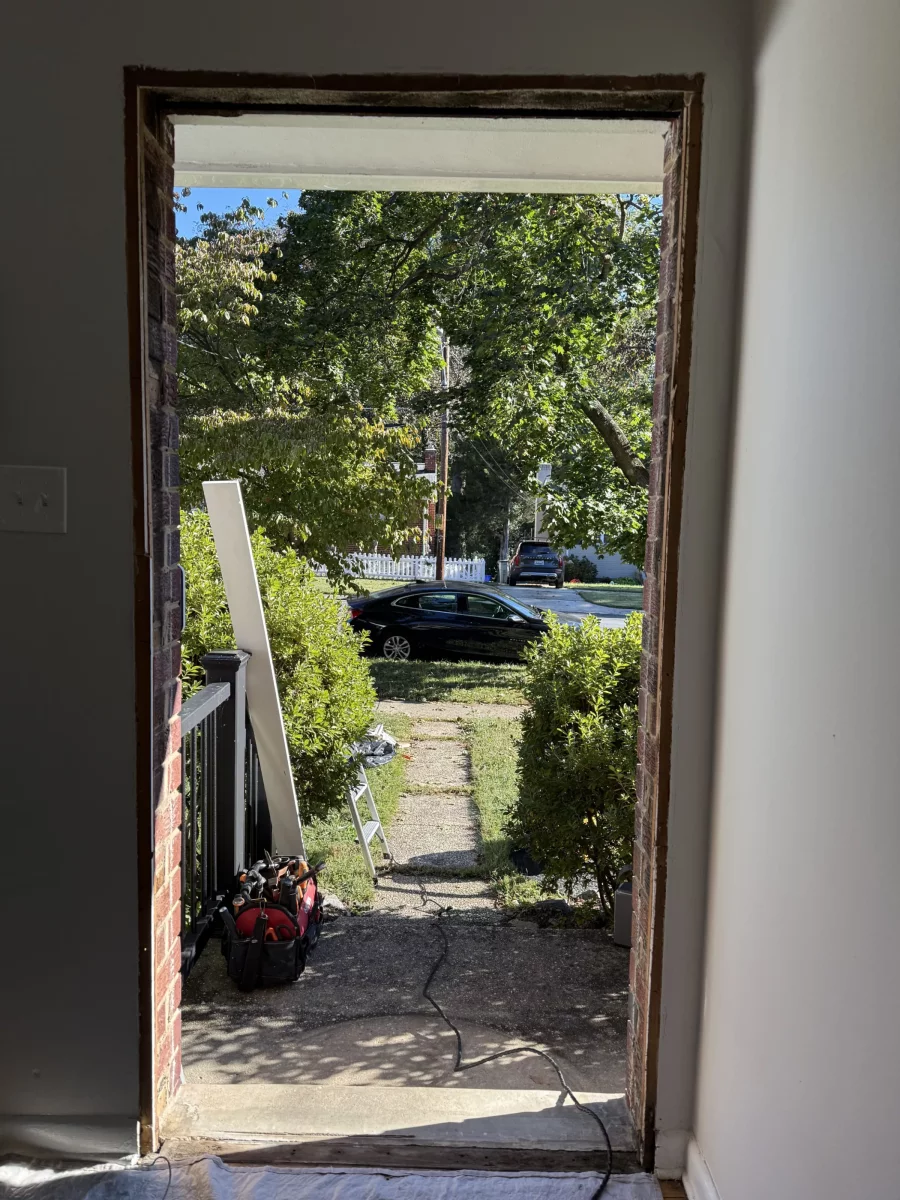 Door opening prepared for installation with tools and drop cloth visible