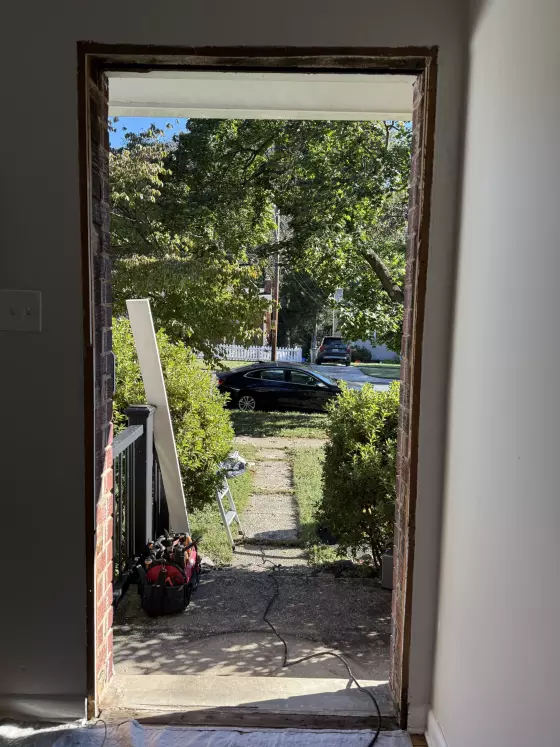 Door opening prepared for installation with tools and drop cloth visible