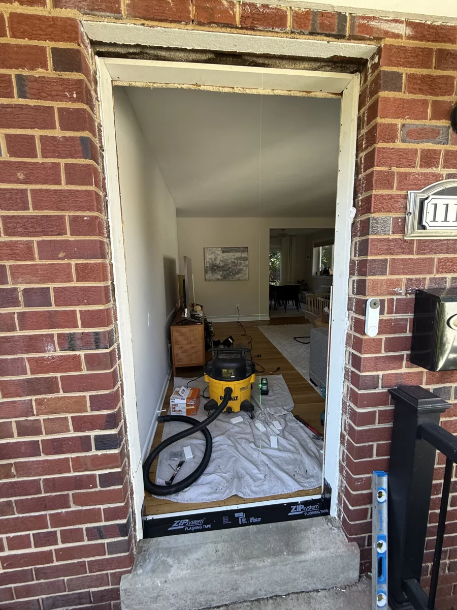 Door opening prepared for installation with tools and drop cloth visible