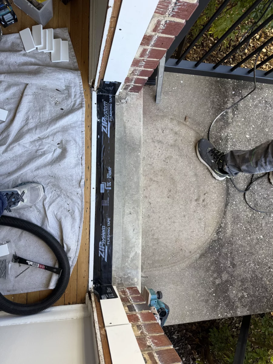Door threshold area with flashing tape and tools during installation