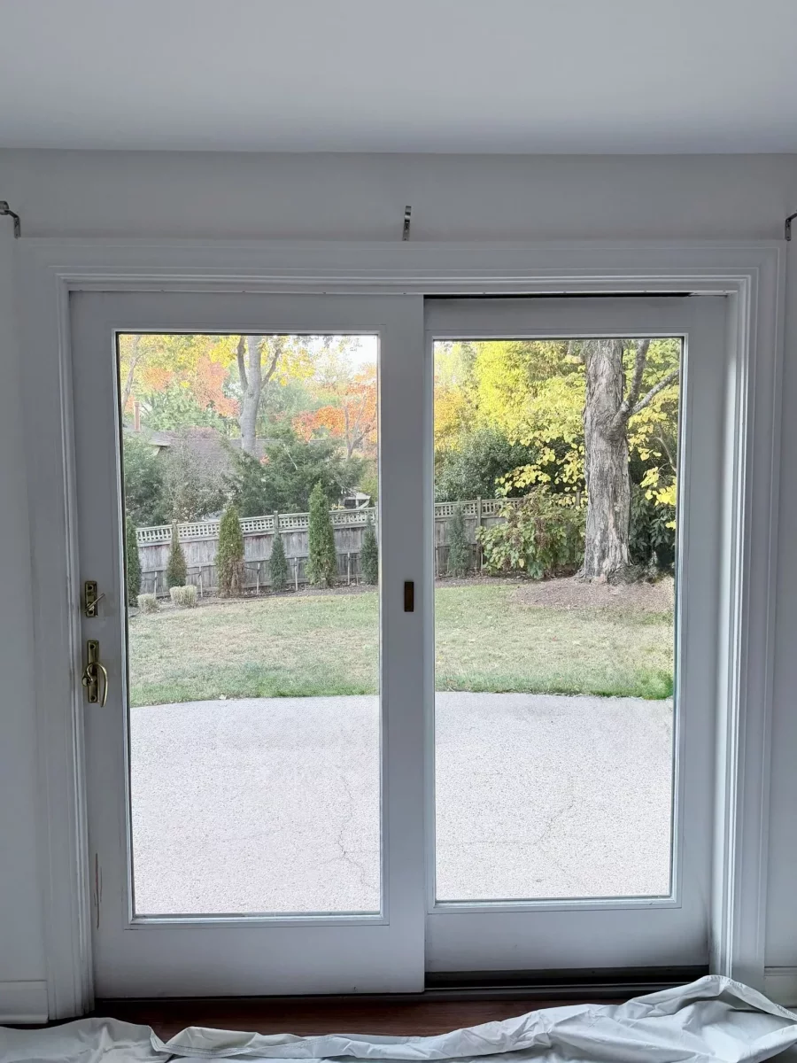 White sliding glass patio door with view of backyard