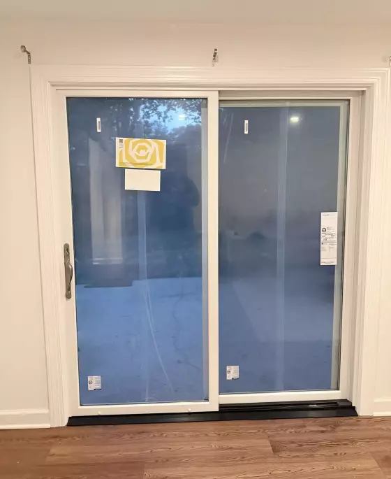 Sliding glass patio door with protective film and labels installed indoors