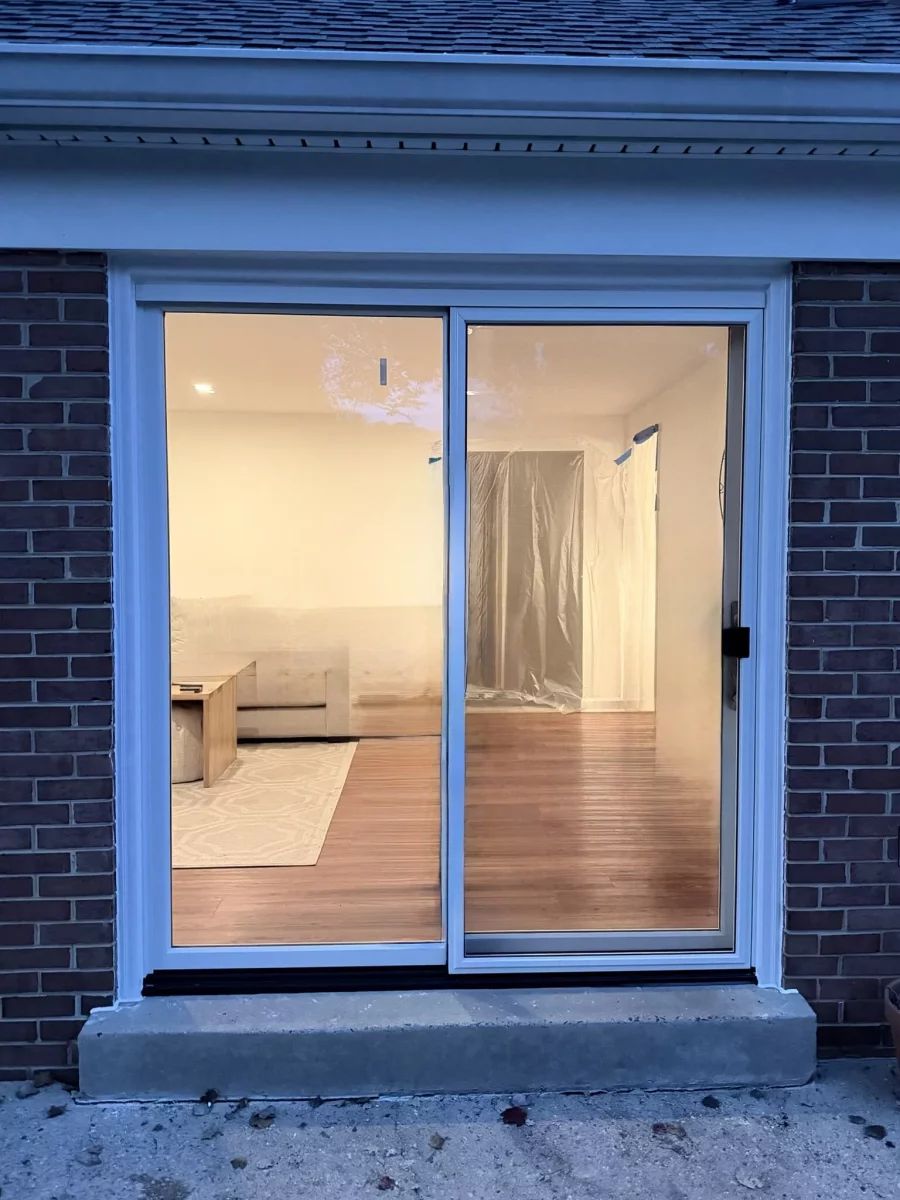 Exterior view of a sliding glass patio door installed in a brick wall