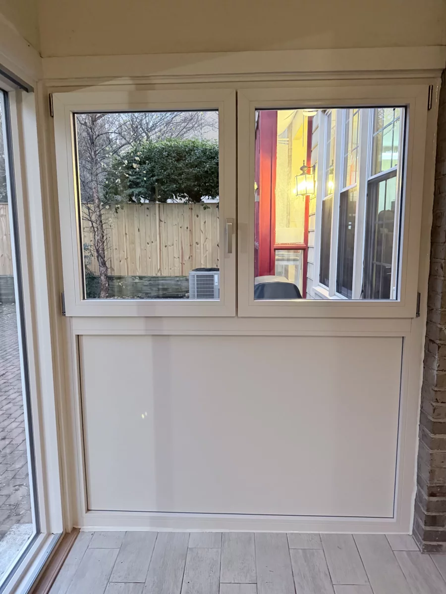 Interior view of cream Oknoplast tilt and turn window above insulated panel in a Potomac, MD sunroom