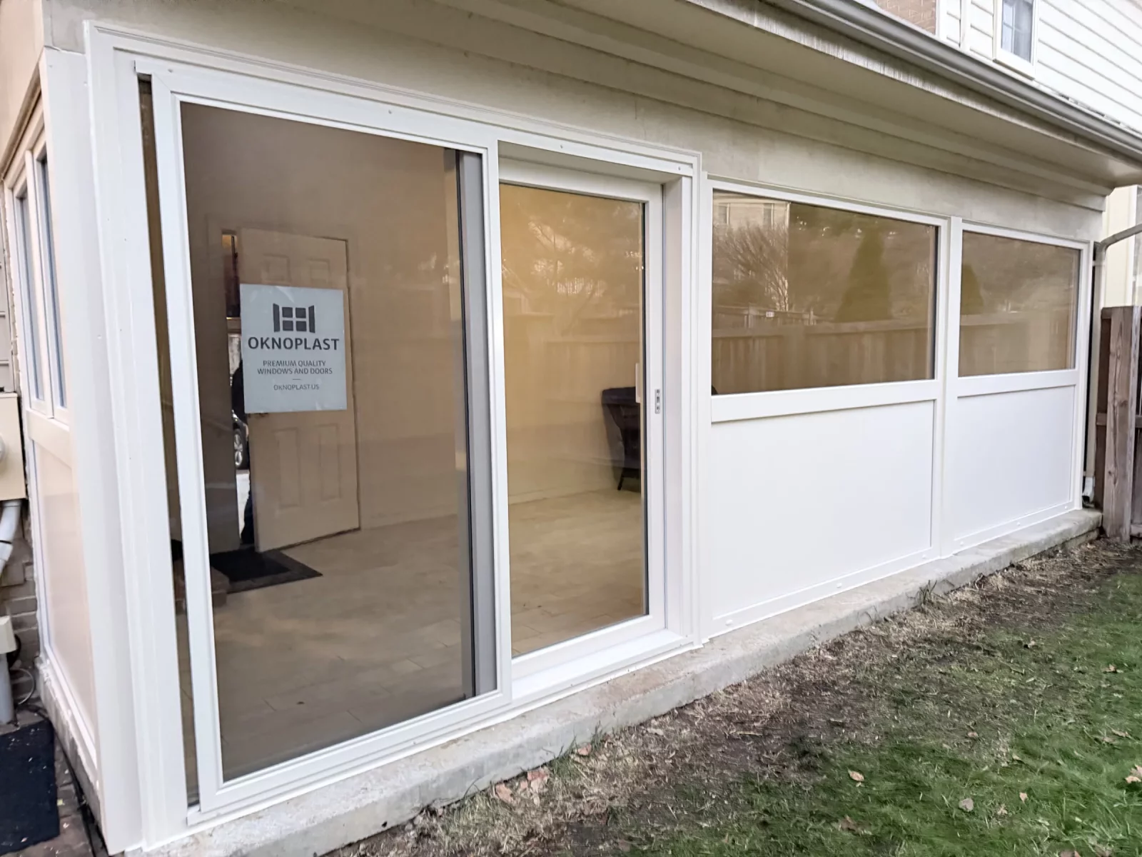 Angled view of cream Oknoplast sliding door and picture windows on a finished porch enclosure in Potomac, MD
