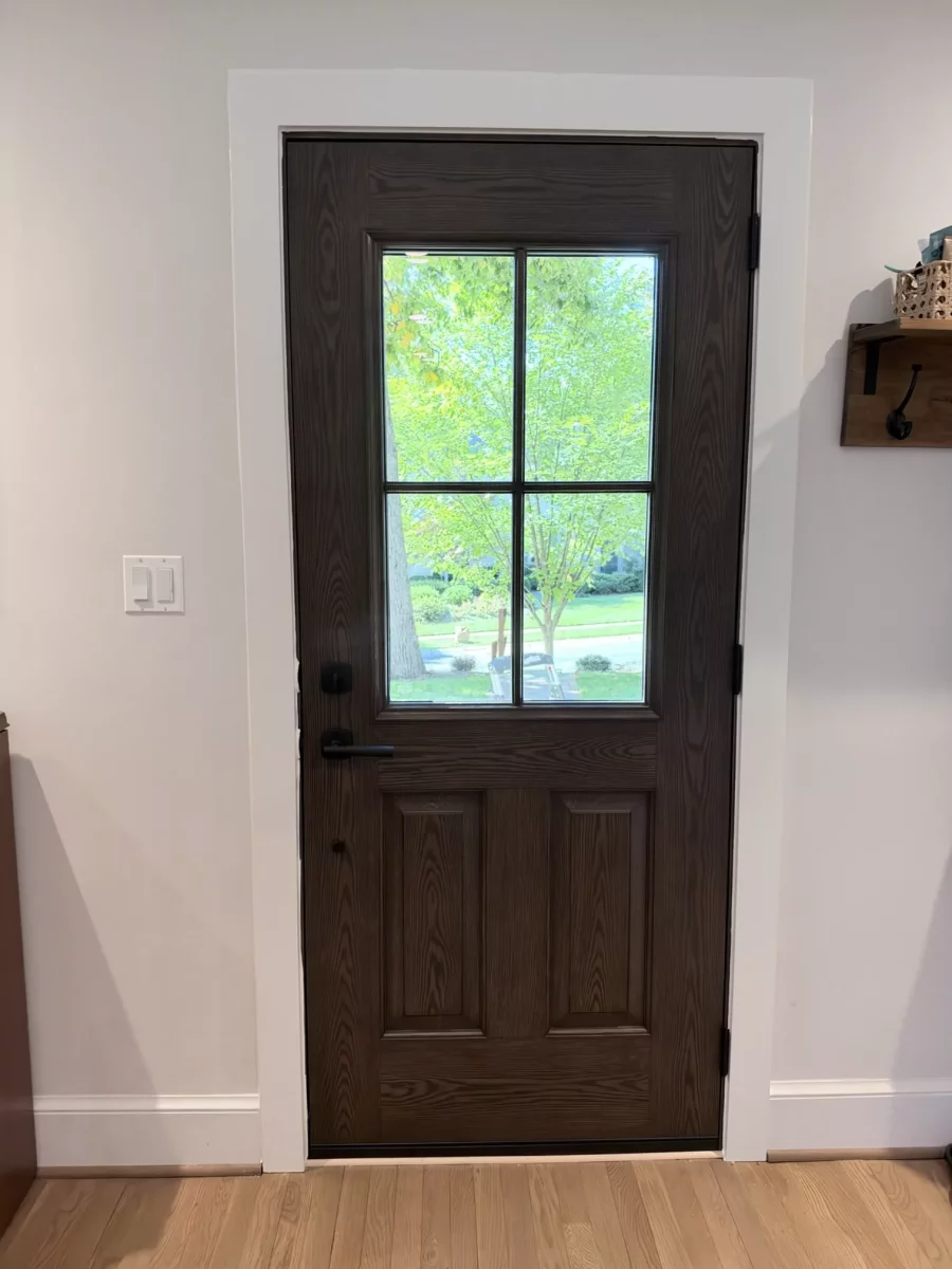 Wood entry door with glass panel viewed from inside a home.