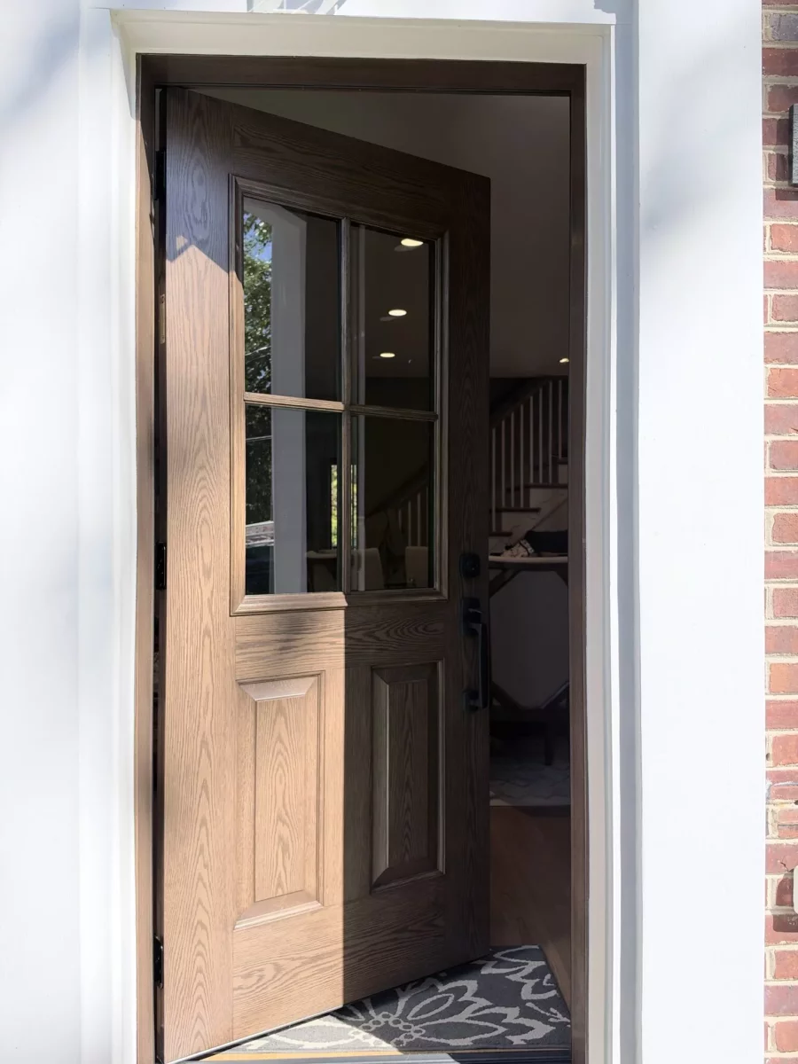 Wood entry door with glass panels open to residential home