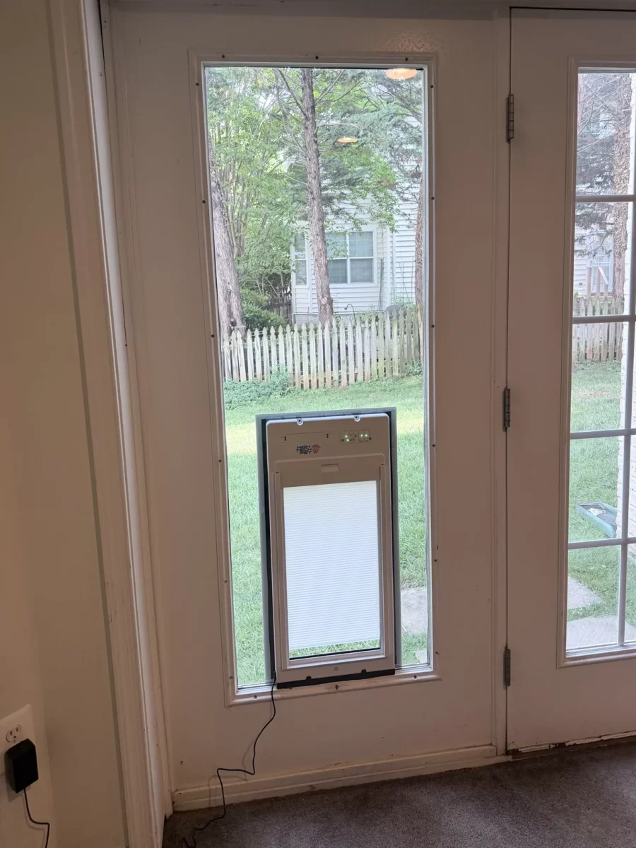 Installed electronic pet door in glass panel next to residential door