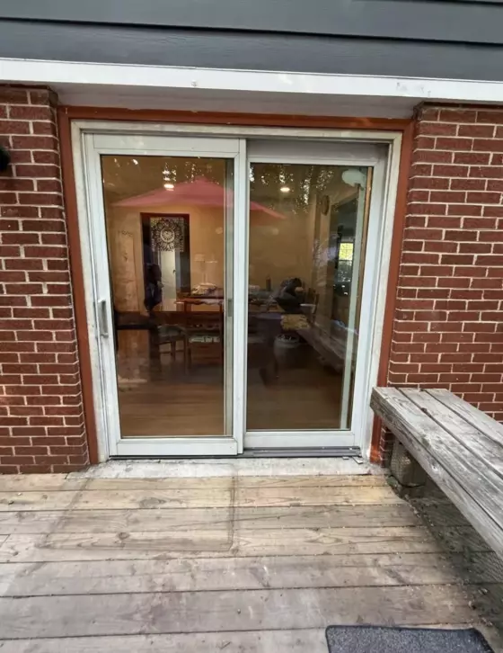 Old sliding patio door in brick wall before replacement, exterior view