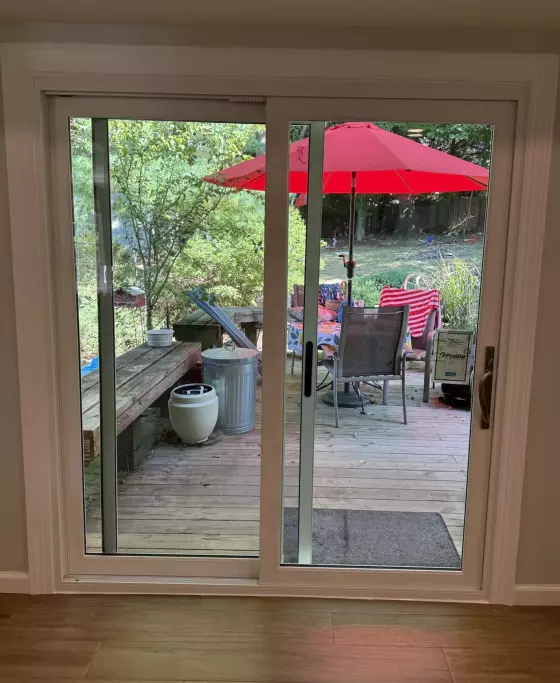 Sliding glass patio door with view to outdoor deck and red umbrella