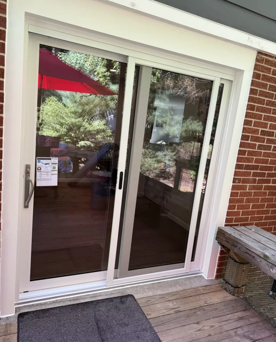 White sliding glass patio door installed on a wooden deck