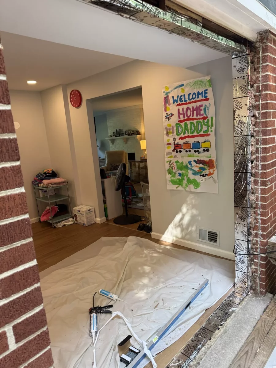 Door opening under construction with tools and drop cloth inside home